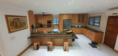 a large kitchen with wooden cabinets and a counter top at Luxury GuesthouseCo RiverHouse in Marloth Park