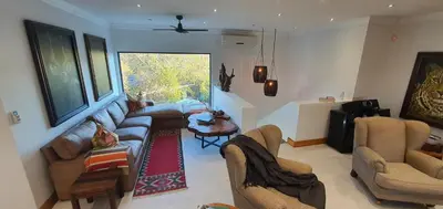 a living room with a couch and a table at Luxury GuesthouseCo RiverHouse in Marloth Park