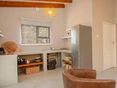 a kitchen with a refrigerator and a chair in it at Monkeys Tail in Marloth Park