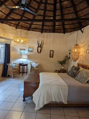a bedroom with a bed and a table in a room at Wild Fig Accommodation in Tzaneen