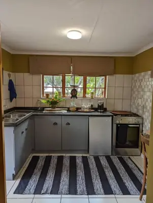 a kitchen with a rug on the floor at Wild Fig Accommodation in Tzaneen