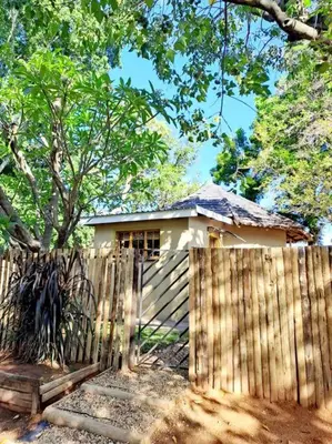 a wooden fence in front of a small house at Wild Fig Accommodation in Tzaneen