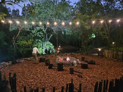 a man standing in front of a fire pit at night at Wild Fig Accommodation in Tzaneen