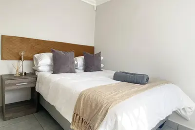 a bedroom with a large bed with a wooden headboard at Gorgeous 2-Bedroom apartment in Secunda