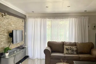 a living room with a couch and a large window at Gorgeous 2-Bedroom apartment in Secunda