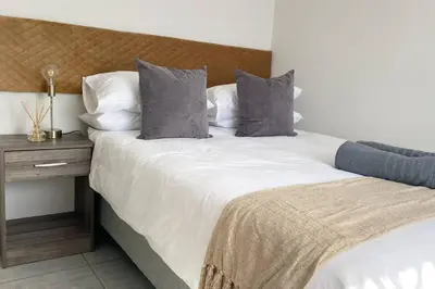 a bedroom with two beds and a wooden nightstand at Gorgeous 2-Bedroom apartment in Secunda