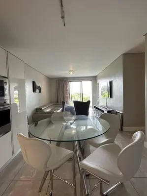 a dining room with a glass table and chairs at House of Grace with Backup power Next to OR Tambo in Kempton Park