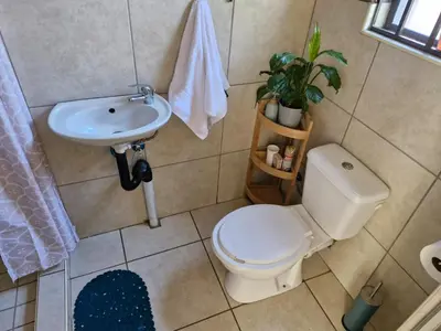 a bathroom with a toilet and a sink at Botle Hive in Kempton Park