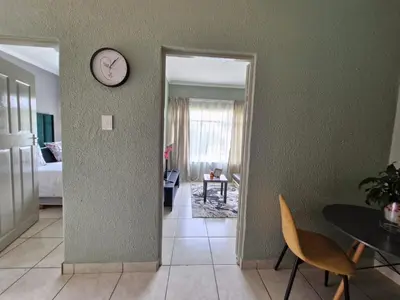 a room with a clock on the wall and a table at Botle Hive in Kempton Park