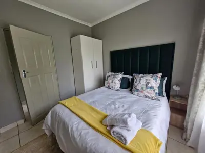 a bedroom with a bed with towels on it at Botle Hive in Kempton Park