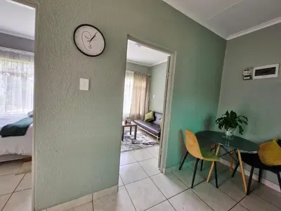 a room with a table and a clock on the wall at Botle Hive in Kempton Park