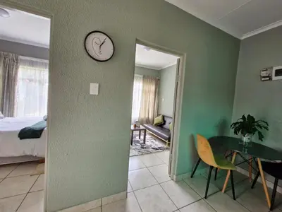 a room with a table and a clock on the wall at Botle Hive in Kempton Park