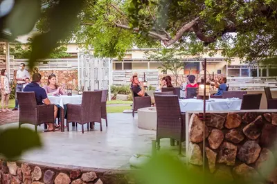a group of people sitting at tables in a restaurant at Bushveld Terrace Safari Hotel, Lodge & Spa in Phalaborwa