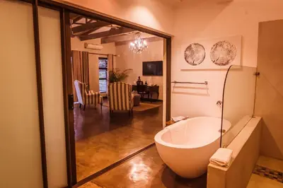 a bathroom with a tub and a dining room at Bushveld Terrace Safari Hotel, Lodge & Spa in Phalaborwa