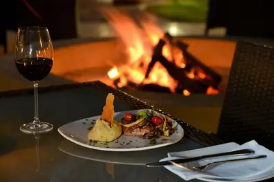 a plate of food next to a glass of wine at Bushveld Terrace Safari Hotel, Lodge & Spa in Phalaborwa