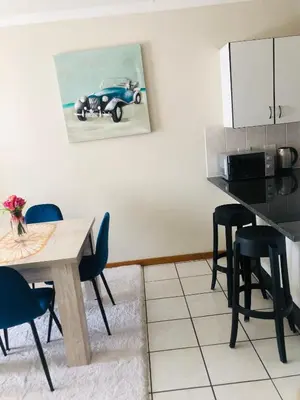 a kitchen with a table and a blue car on the wall at Menlyn Hub Accommodation in Pretoria