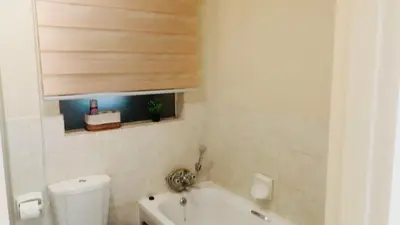 a bathroom with a toilet and a tub and a sink at Menlyn Hub Accommodation in Pretoria
