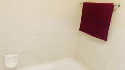 a white bathroom with a red towel on the wall at Menlyn Hub Accommodation in Pretoria