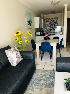 a living room with a couch and a table at Menlyn Hub Accommodation in Pretoria