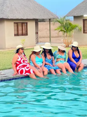 a group of women in bathing suits sitting in the water at In The Bush Farm Lodge in Winterveld