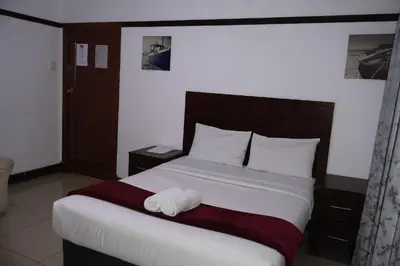 a bedroom with a bed with two towels on it at Khaya Mnandi Leisure Suites in Pretoria