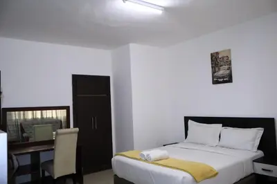 a bedroom with a bed and a desk with a chair at Khaya Mnandi Leisure Suites in Pretoria