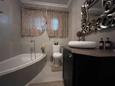 a bathroom with a tub and a toilet and a sink at Hillside Manor in Dalmada AH