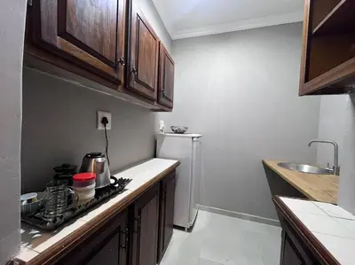 a small kitchen with a stove and a refrigerator at Hillside Manor in Dalmada AH