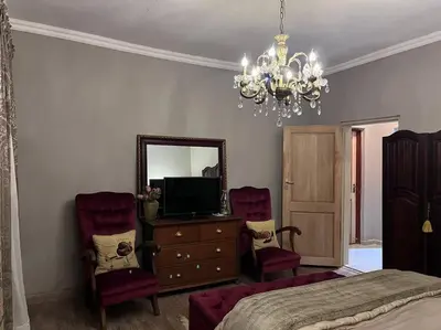 a bedroom with a bed and a dresser with a mirror at Hillside Manor in Dalmada AH