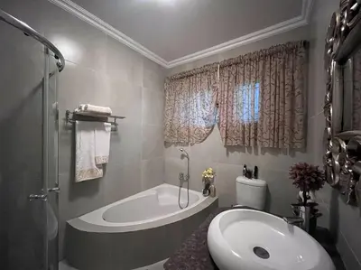 a bathroom with a tub and a toilet and a sink at Hillside Manor in Dalmada AH
