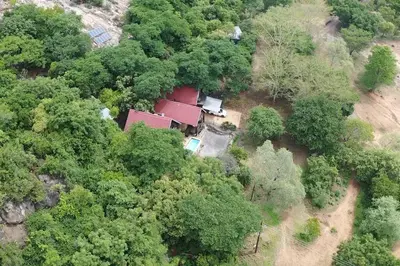 an aerial view of a red house in the forest at Serenity Farm House in Karino