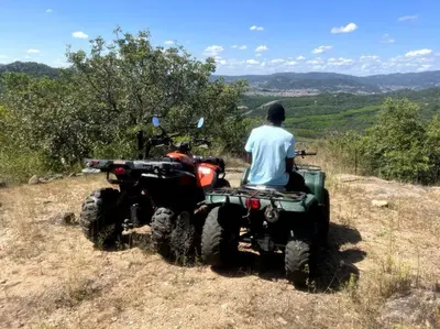 a man sitting on a quad bike on a hill at Serenity Farm House in Karino