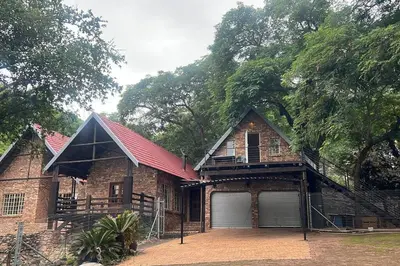 a large brick house with a red roof at Serenity Farm House in Karino
