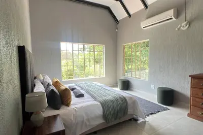 a bedroom with a bed and two windows at Serenity Farm House in Karino