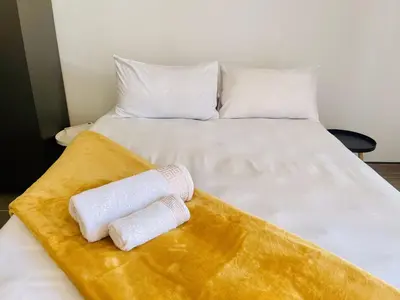 a bed with two rolled towels on top of it at TrendyBliss Guest House - n0016 in Northam