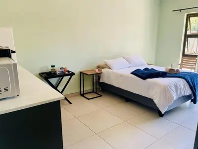 a small bedroom with a bed and a table at TrendyBliss Guest House - n0016 in Northam