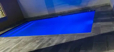 a large blue swimming pool in a room at TrendyBliss Guest House - n0016 in Northam
