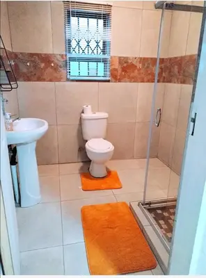 a bathroom with a toilet and a sink at Reutlwane Gardens Apartments in Secunda
