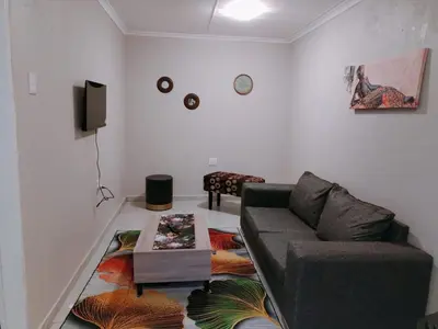 a living room with a couch and a table at Reutlwane Gardens Apartments in Secunda