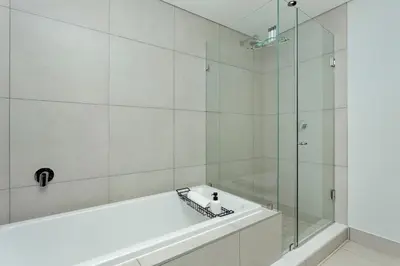 a bathroom with a tub and a glass shower at Ellipse Waterfall on Magwa cres in Midrand