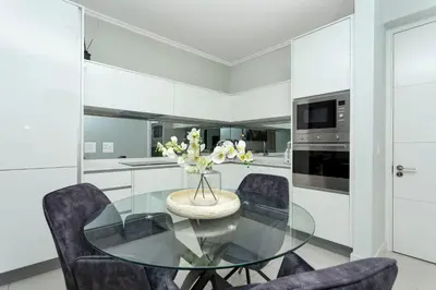 a kitchen with a glass table and chairs at Ellipse Waterfall on Magwa cres in Midrand