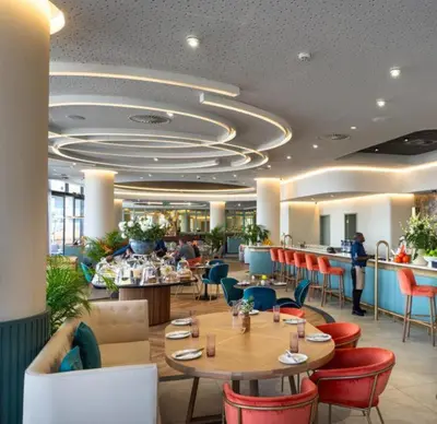 a restaurant with tables and chairs and people in it at Ellipse Waterfall on Magwa cres in Midrand