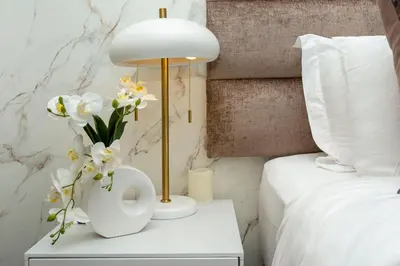 a white table with a lamp and flowers on it at Ellipse Waterfall on Magwa cres in Midrand