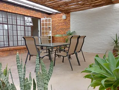 a table and chairs on a patio with plants at Wapadrand Guest Suite in Pretoria