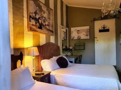 a bedroom with two beds and a hat on the bed at Waterhouse Guest Lodge - Indus Street in Pretoria