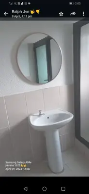 a bathroom with a white sink and a mirror at Riverside guesthouse in Phalaborwa