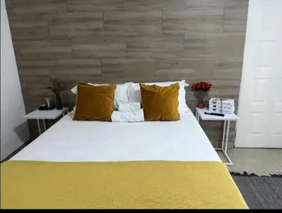 a large bed with yellow and white pillows at Riverside guesthouse in Phalaborwa