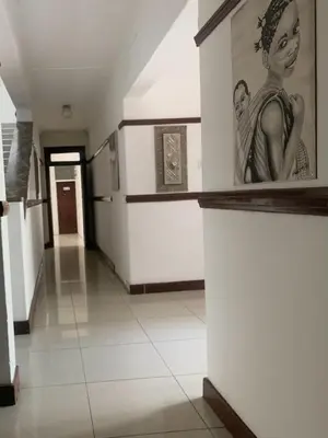 a hallway with a painting of a woman on a wall at Khaya Mnandi Leisure Suites in Pretoria
