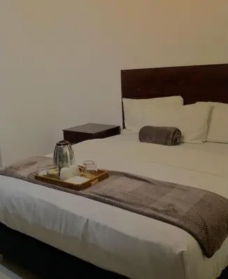 a bed with a tray on top of it at Khaya Mnandi Leisure Suites in Pretoria
