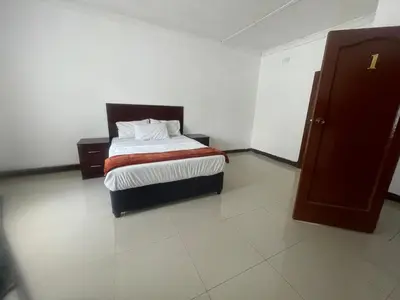 a bedroom with a bed in a room at Khaya Mnandi Leisure Suites in Pretoria